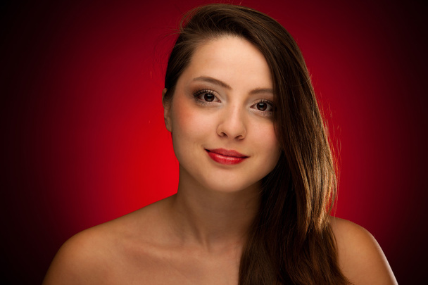 Beauty portrait of a cute caucasian woman over red background - Fotó, kép
