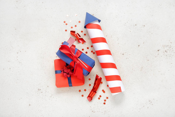 Gift boxes with firework rocket, USA flag and ribbon on grunge white background. American Independence Day - Fotoğraf, Görsel