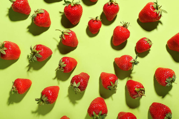 Many fresh strawberries on green background - Foto, afbeelding