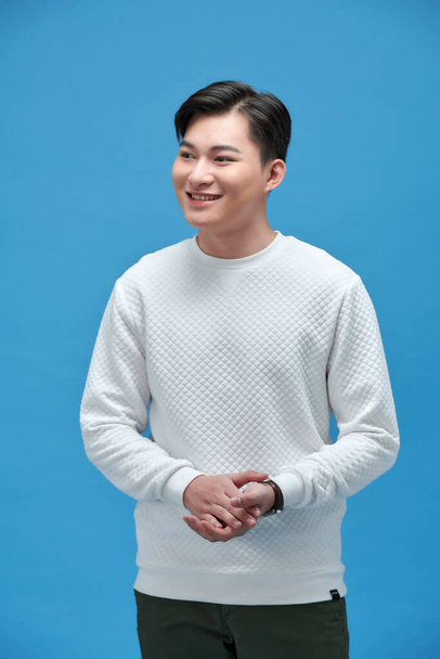 young happy asian man standing with arms crossed over blue wall - Foto, Imagem