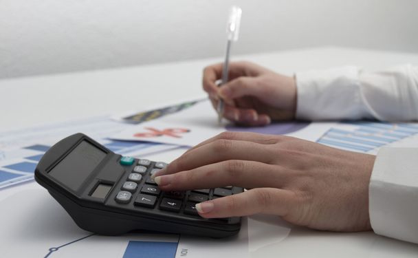 Joven empresaria calculando documentos financieros
 - Foto, Imagen