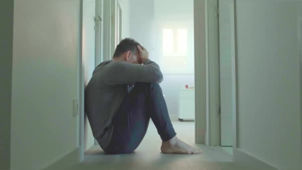 Женщина-психиатр разговаривает с пациентом-мужчиной с психическим расстройством и суицидальными мыслями, сидя на полу в комнате в коридоре - Кадры, видео