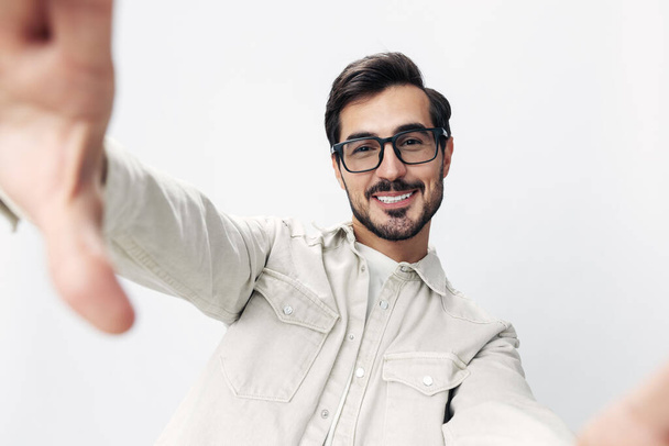 Detailní portrét muž bere selfie s brýlemi úsměv se zuby radost na bílém izolovaném pozadí, módní styl oblečení, kopírovací prostor, prostor pro text. Kvalitní fotografie - Fotografie, Obrázek