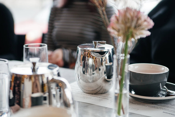 gyönyörű asztal beállítás virágokkal, poharakkal és egy csésze kávéval - Fotó, kép