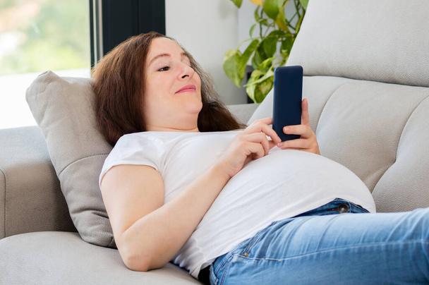 Comfortable woman at home texting on a mobile phone - Foto, Imagen