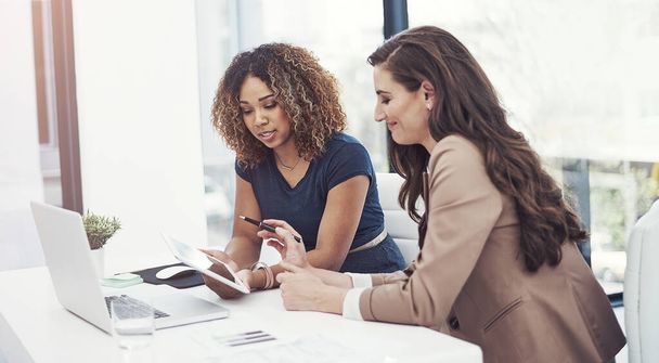 Combinando o seu talento empresarial. duas mulheres de negócios que usam um tablet digital juntas durante uma colaboração no trabalho - Foto, Imagem
