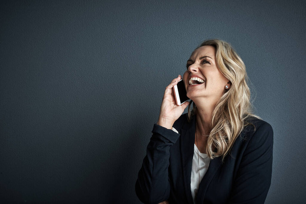 Сделайте этот звонок, чтобы ваш бизнес процветал. Студийный снимок взрослой деловой женщины, разговаривающей по мобильному телефону на сером фоне - Фото, изображение