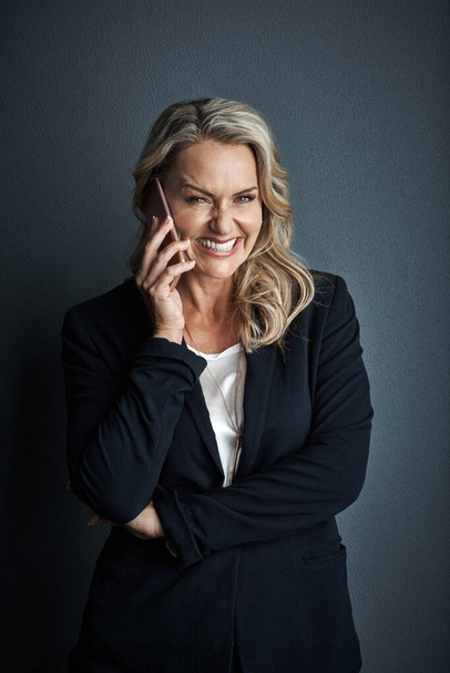 Success comes naturally to her. Studio portrait of a mature businesswoman talking on a cellphone against a grey background - Foto, Imagem
