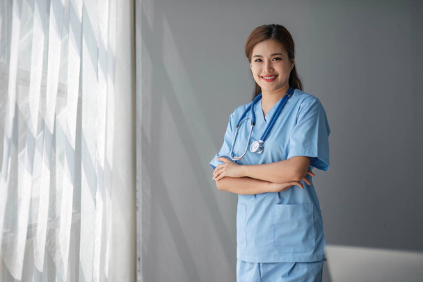 Προσωπογραφία γυναίκας Ασιάτισσας γιατρού που στέκεται στο γραφείο της στην κλινική... - Φωτογραφία, εικόνα