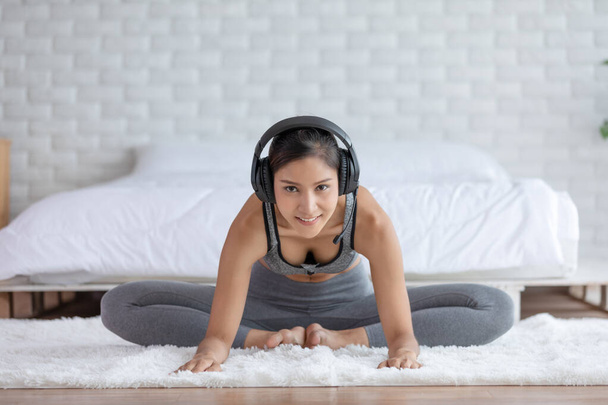 Calm of Asian woman in sportwear stretching muslce to warm up breathing and meditation with yoga at home.Healthy female doing yoga Feeling so comfortable and relax,Wellness Yoga Healthcare Concept - Photo, image