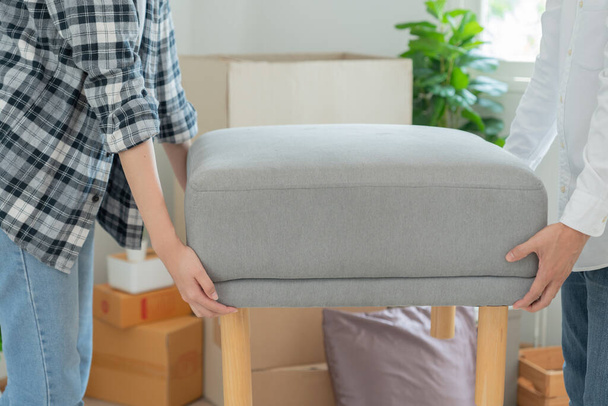 Moving house, relocation. Couple help set and move furniture for new apartment, inside the room was a cardboard box contain personal belongings. move in the new apartment or condominiu - Photo, Image