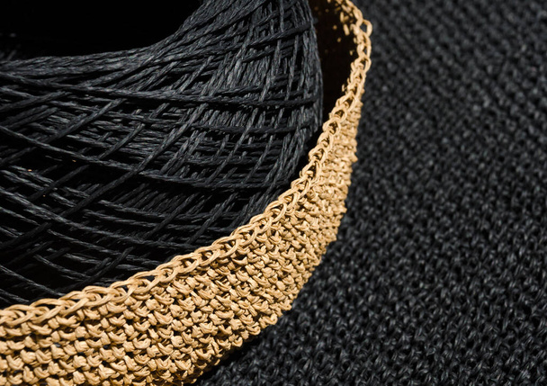 A skein of black raffia in a woven bowl of beige raffia. Handmade, hobby. - Photo, Image
