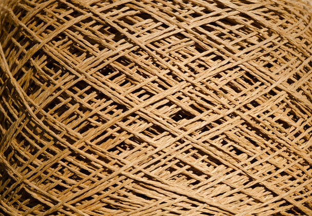Raffia ist eine organische Holzfaser, die leicht zu häkeln ist. Fabrik-Rolle aus gewickeltem Bast, gebrauchsfertig. - Foto, Bild