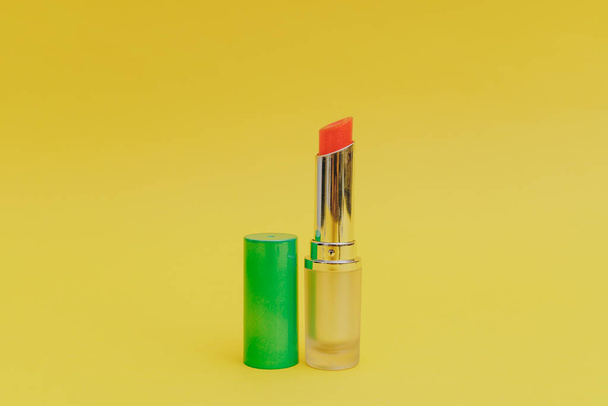 Lippenstift mit leuchtend grüner Kappe auf gelbem Hintergrund - Foto, Bild