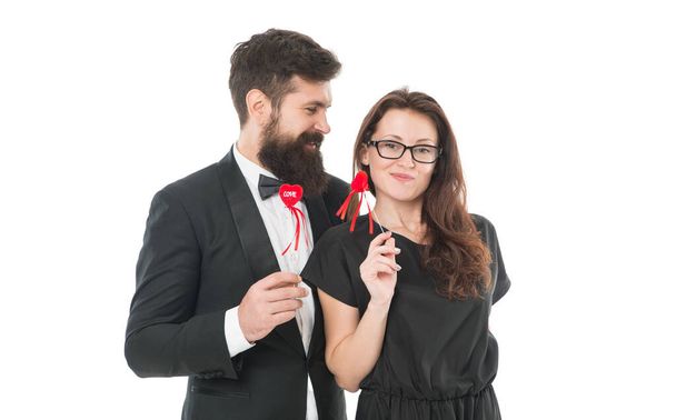 Married couple hold red hearts. Happy relationship concept. Trustful relations. Happy valentines day. Couple in love. Family couple. Bearded man in tuxedo hug elegant woman. Proposal and engagement. - Фото, зображення