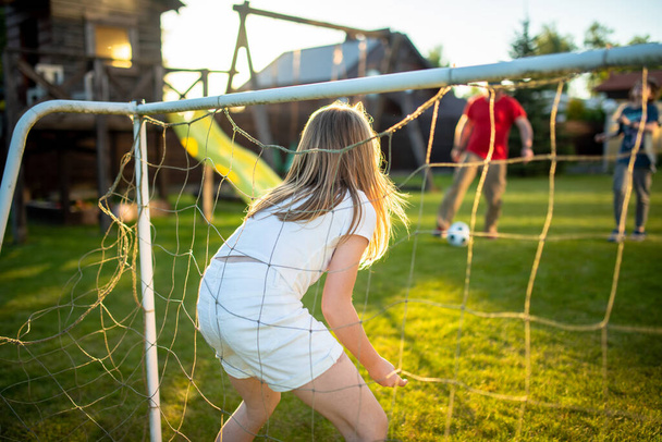 Cute young soccer player having fun playing a soccer game on sunny summer day. Preteen girl playing sports games outdoor. Active leisure. - Foto, immagini