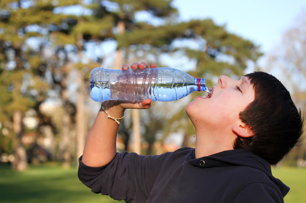 Un ragazzo assetato di acqua potabile dalla bottiglia di plastica
 - Foto, immagini