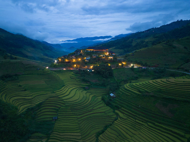 Górny widok z lotu ptaka tarasy ryżowe świeże, zielone pola rolnicze na wsi lub obszarów wiejskich Mu Cang Chai, górskie wzgórza doliny w Azji, Wietnam. Krajobraz przyrody. - Zdjęcie, obraz