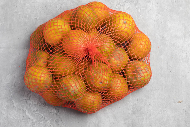 Fresh oranges in net bags for juice - Фото, зображення
