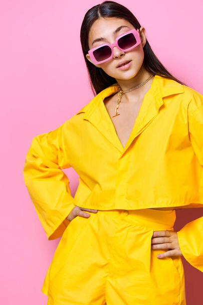 occhiali da sole donna rosa felice bella ragazza stile di vita persona attraente moda moderno isolato giovane femmina giallo bruna espressione ritratto alla moda allegro divertimento - Foto, immagini