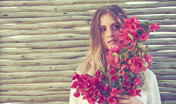 Nothing says femininity quite like flowers. an attractive young woman holding a bunch of fresh flowers - Foto, Imagem