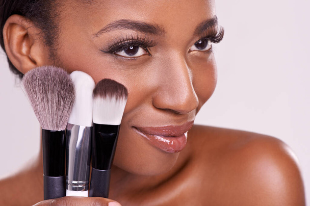 Cosmetic brushes, makeup and black woman with smile on face in studio and beauty application tool. Skincare, blush and cosmetics, facial skin model with luxury contour product on white background. - Photo, image