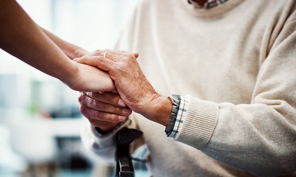 Je bent nu in mijn handen. een onherkenbare vrouwelijke verpleegster houdt haar oudere patiënten hand in hand comfort - Foto, afbeelding