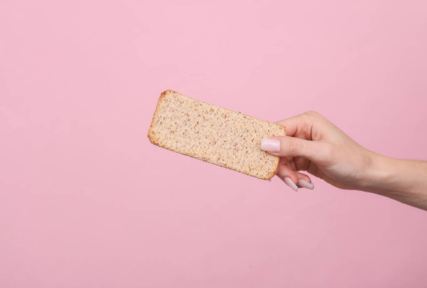 Жінка тримає дієтичний хліб на рожевому тлі. Дієта, концепція втрати ваги - Фото, зображення