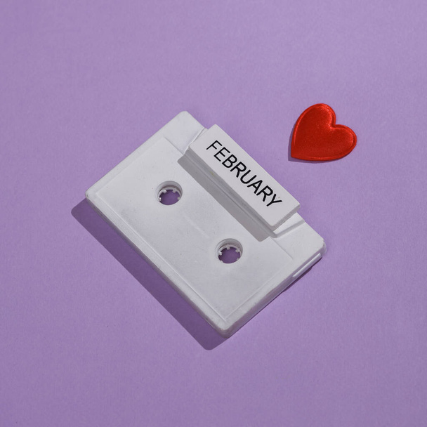 Creative valentine's day layout with audio cassette on purple background - Photo, Image
