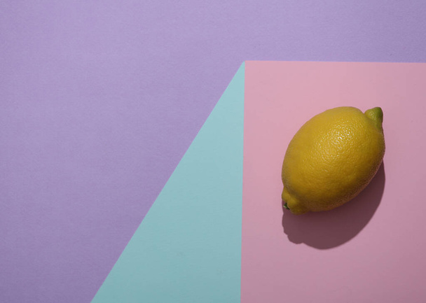 Lemon on a paper cube. Optical illusion. Food concept. Geometric composition. Minimalistic creative layout - Foto, afbeelding