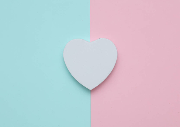 Біла коробка у формі серця на рожево-блакитному пастельному фоні - Фото, зображення