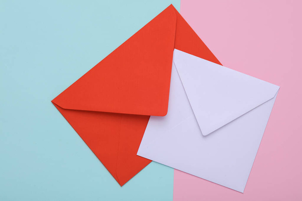 Red and white envelopes on a pastel background - Foto, imagen
