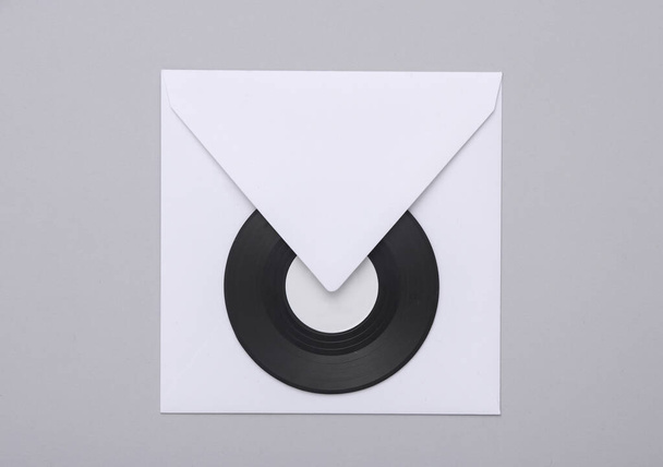 White envelope with vinyl record on gray background - Photo, Image