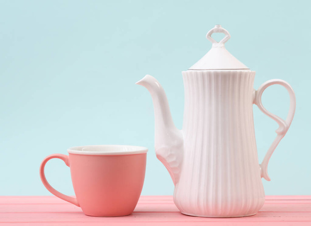 White ceramic teapot with cup on a pastel background - Фото, изображение