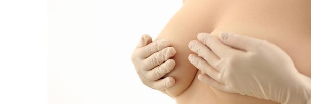 Las mujeres con guantes de goma cubren los senos desnudos. Concepto de salud mamaria y cuidado de la piel y aumento de senos femeninos - Foto, imagen