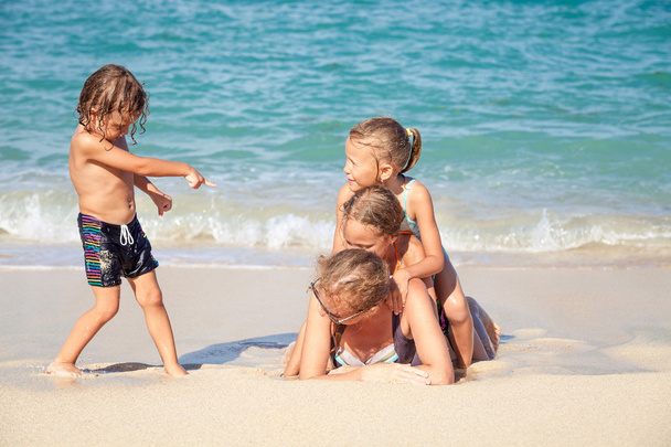 счастливая семья играет на пляже в дневное время
 - Фото, изображение