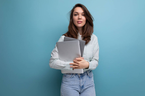 brunette young business woman in shirt with documents and laptop against background with copy pace. - Photo, Image