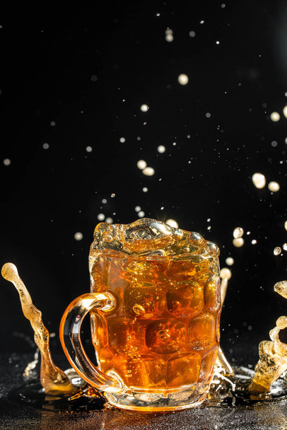 Beer with foam splash. Freeze motion splash drops of beer foam. - Photo, Image