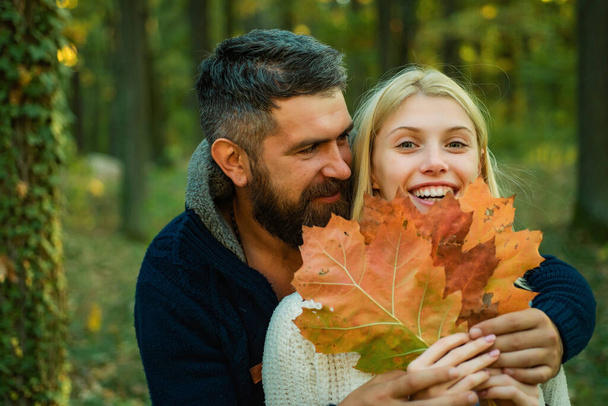 fröhliches unbeschwertes Herbstpaar im Park an einem sonnigen Tag. Herbst Modeporträt eines Paares mit herbstlicher Stimmung. Romantik und Liebe - Foto, Bild