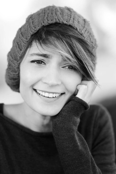 帽子とコートと黒と白の美しい笑顔の女の子の肖像画  - 写真・画像
