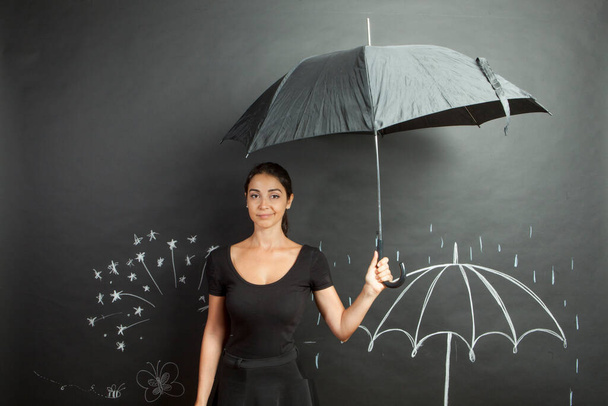 žena oblečená v černém v dešti s deštníkem - kreslené křídové pozadí - Fotografie, Obrázek