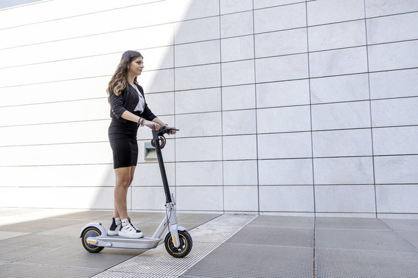 kobieta menedżer z jej skuter w nowoczesnym środowisku miejskim - Zdjęcie, obraz