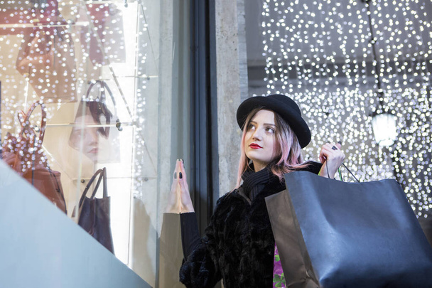 Красива жінка з коричневим волоссям пофарбована в фіолетовий колір навколо магазинів, щоб піти на покупки - Фото, зображення