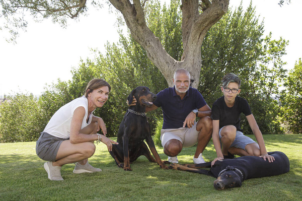 Beautiful family with dogs, smiling happy in the lawn of the home garden - Φωτογραφία, εικόνα