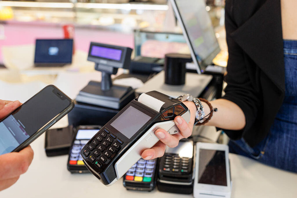 płatność za telefon komórkowy. kobieta korzystająca z karty kredytowej w centrum handlowym.  - Zdjęcie, obraz