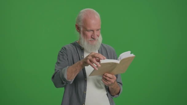 Zielony ekran. Portret mądrego staruszka z siwą brodą, czytającego książkę. Starszy człowiek przewraca się przez strony książki. Wolny czas, Hobby Concept. - Materiał filmowy, wideo