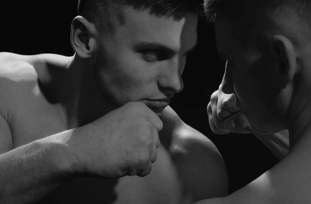 Close up portrait of two muscular men fighting, punching each other, boxing or mma - Foto, afbeelding