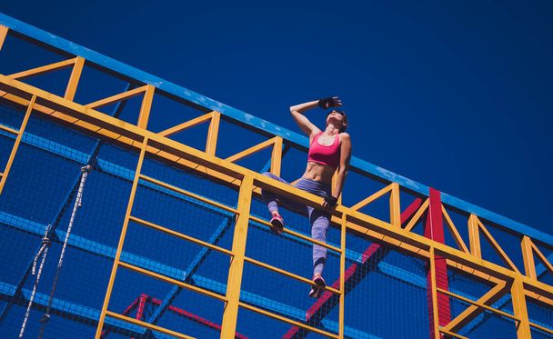 Athletic young woman working out and climbing at the training camp - Foto, Bild