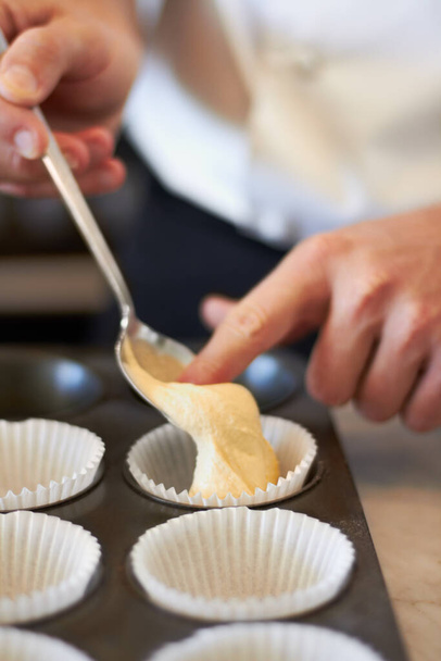 Closeup, hands and muffin dough in tray with baker, small business owner and professional chef. Cooking, bakery and cake in baking pan for food, job or start process for cupcake in restaurant kitchen. - Foto, imagen