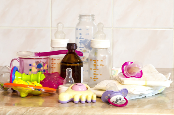 Szklana butelka z mieszanki do karmienia, zabawki i baby pieluszki - Zdjęcie, obraz